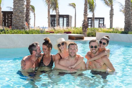 brooks and julianne along with two couples on each side in the pool hugging one anotherr 